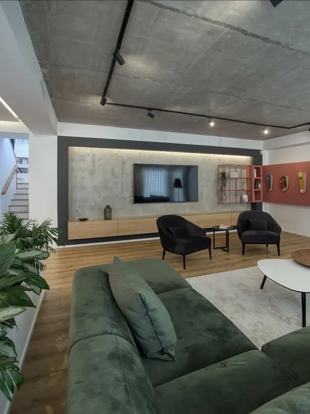Salon style loft avec plafond béton et canapé vert