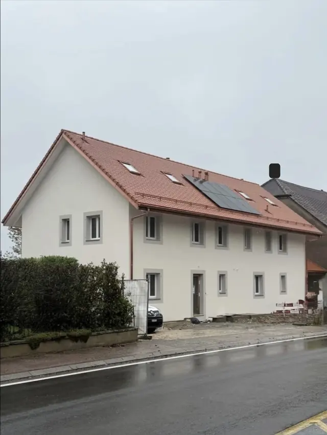 Bâtiment rénové avec toiture neuve et façade crépie