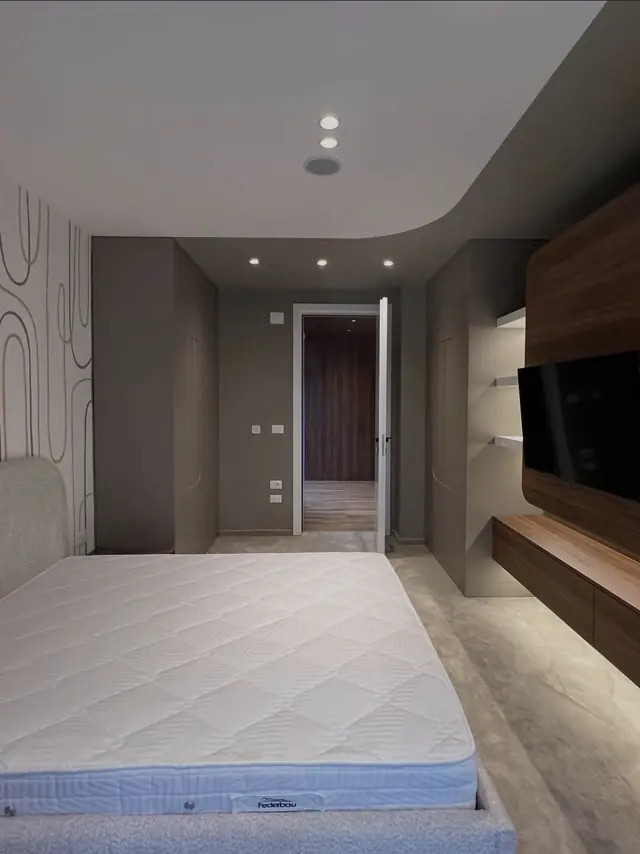 Chambre aux teintes sombres et meuble TV en bois
